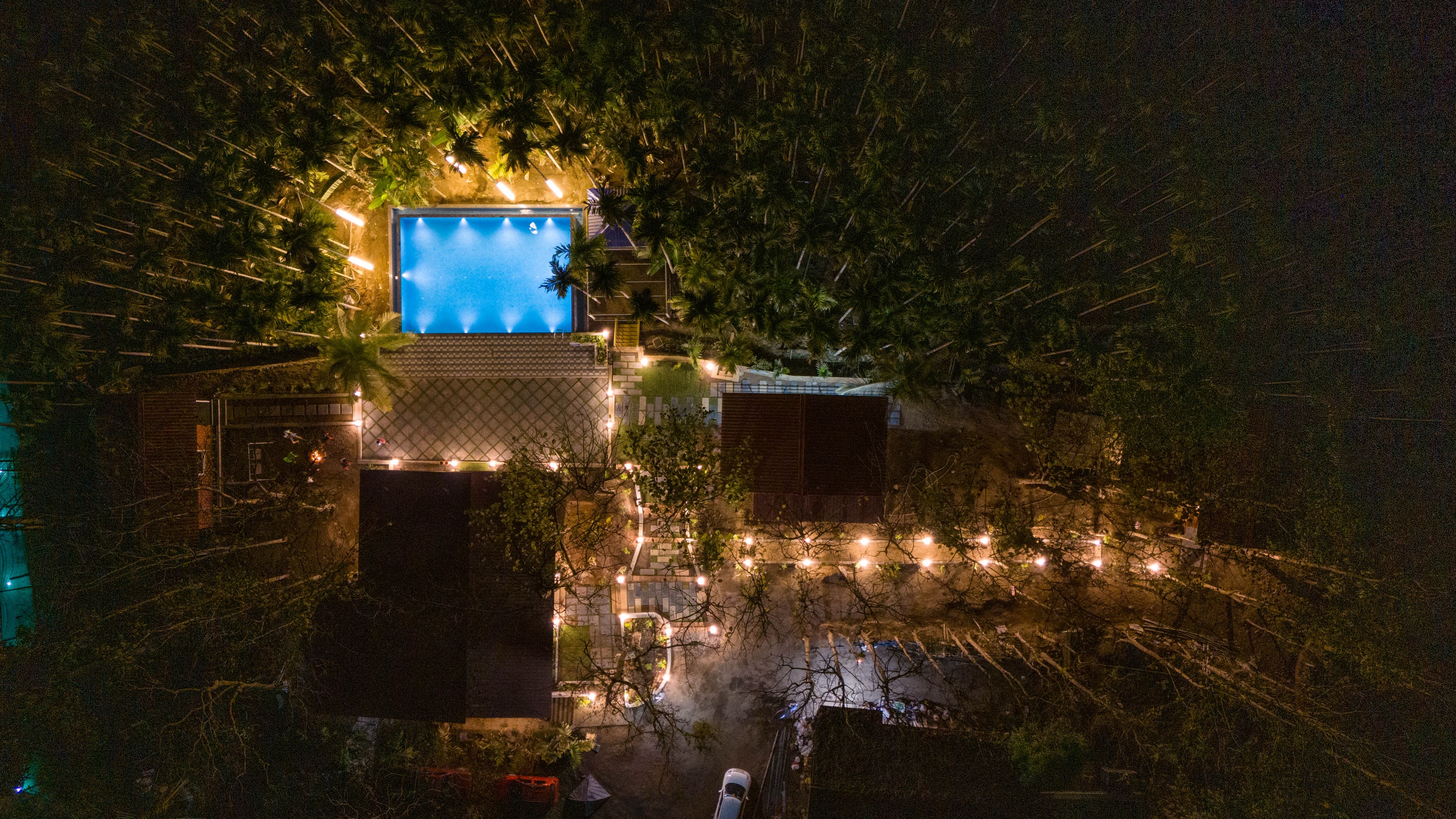 Aerial drone shot of the resort and swimming pool at night