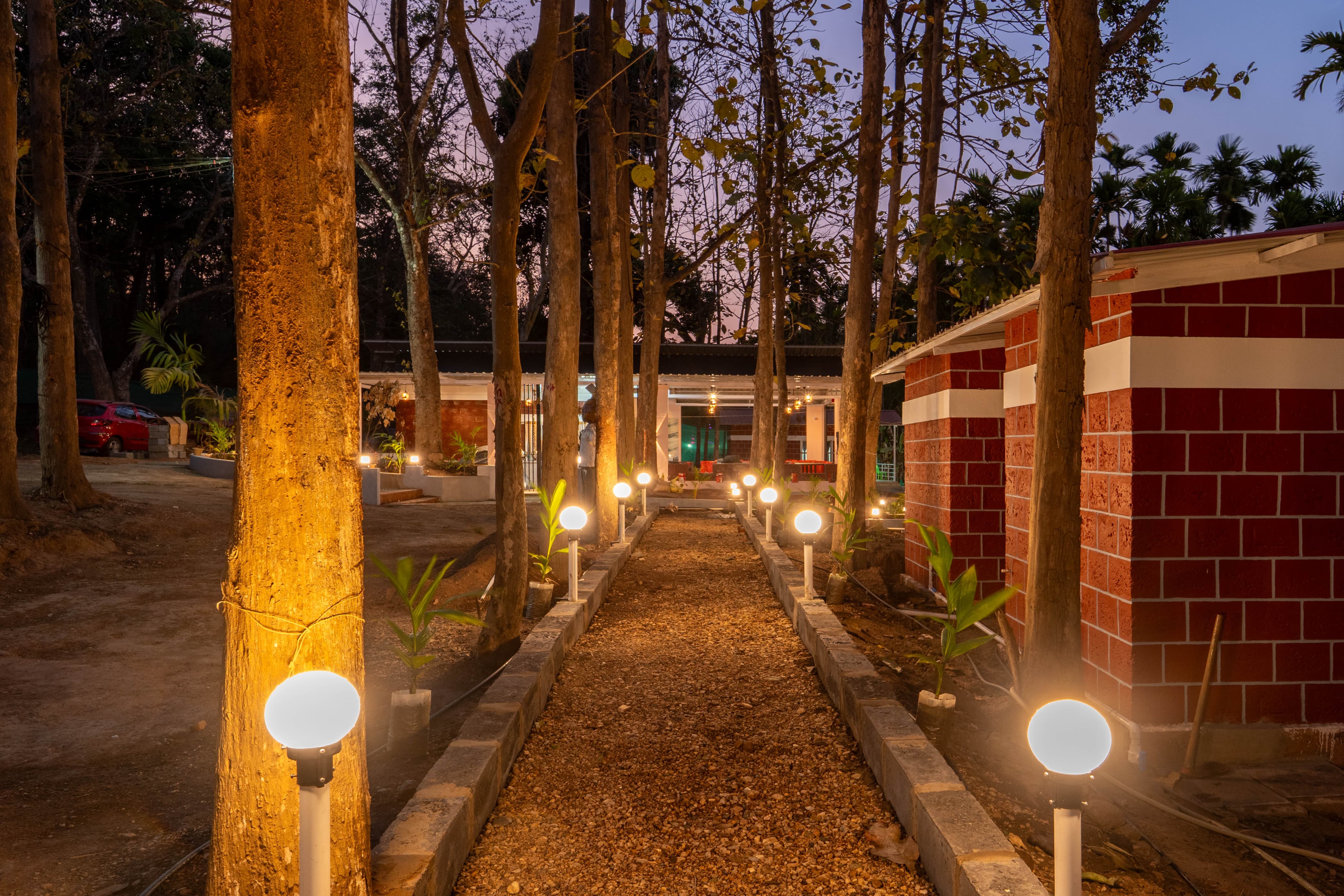 A tranquil pathway lit by lamps at Infinity Junglestay