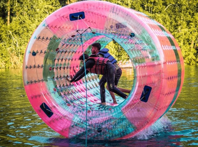 Guests enjoying water zorbing in a giant inflatable ball at Infinity Junglestay